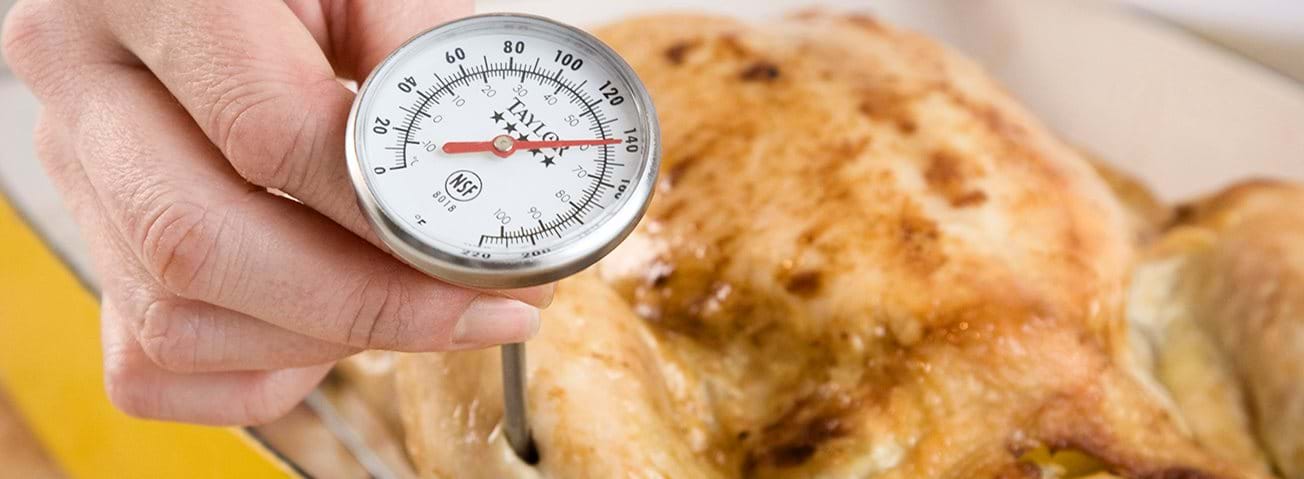 Closeup of a meat thermometer in baked poultry.
