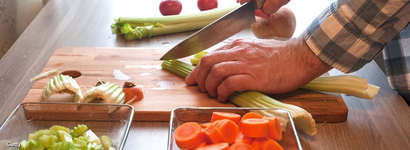 Man chopping vegetables for a meal.