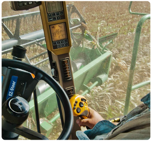 Farmer steering tractor in crop field
