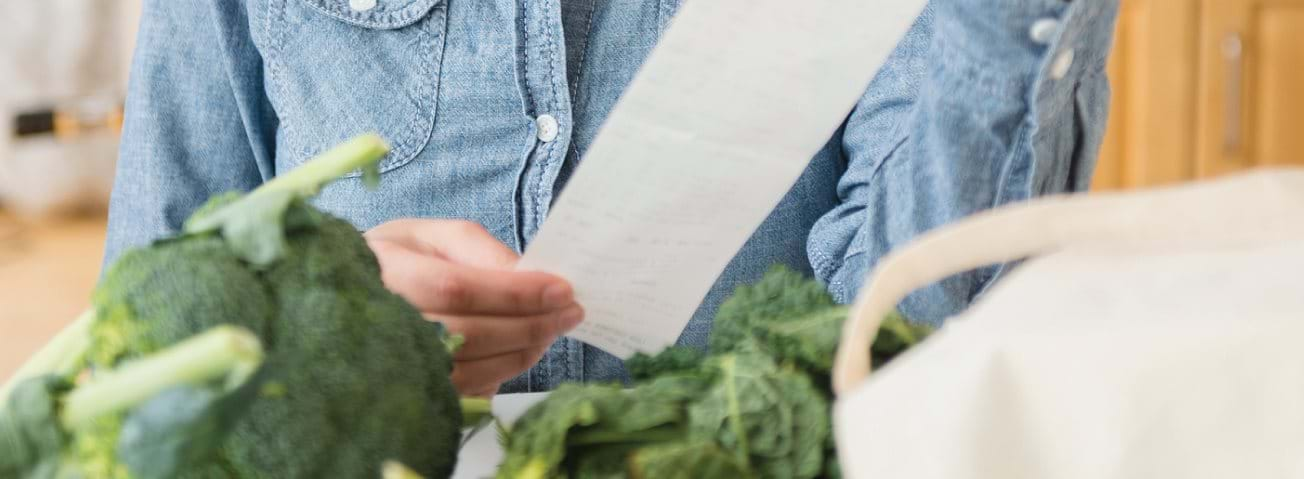 Photo of a shopper reading a grocery receipt.