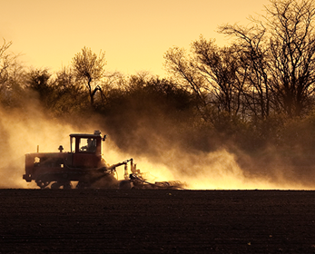 Sepia-toned photo of tractor working a field