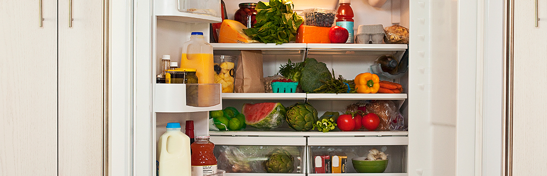 Photo of an open refrigerator filled with a variety of food and drinks.