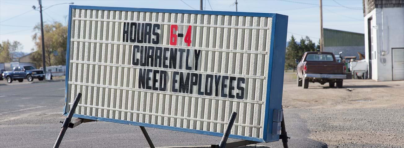 Sign board in rural setting advertising need for employees