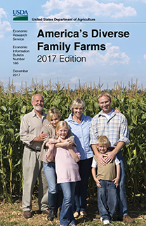 Family of three generations by corn field, smiling, portrait