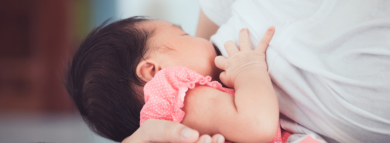 Child breastfeeding with mother