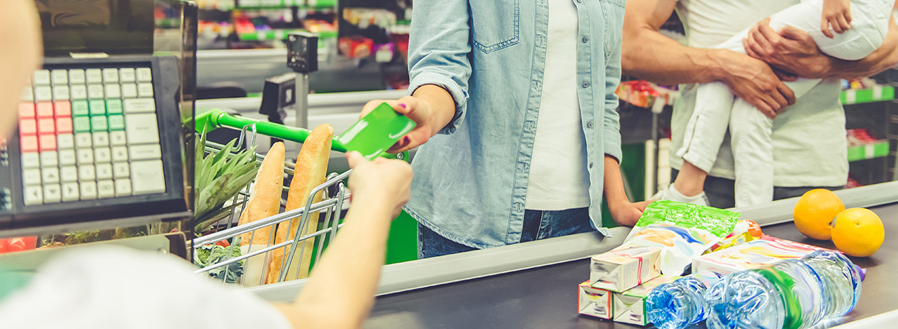 Parents with young child in supermarket checkout line