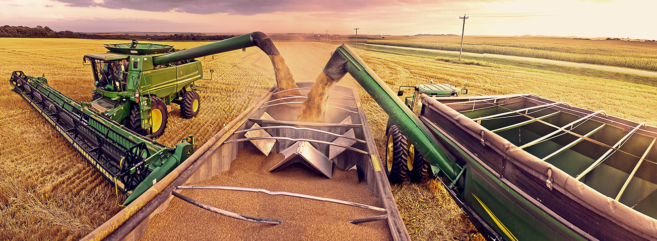 Combines off-loading grain into a bin on a farm.