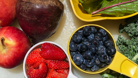 Tabletop with a variety of fresh fruits and vegetables.