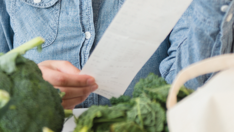 Photo of a shopper reading a grocery receipt.