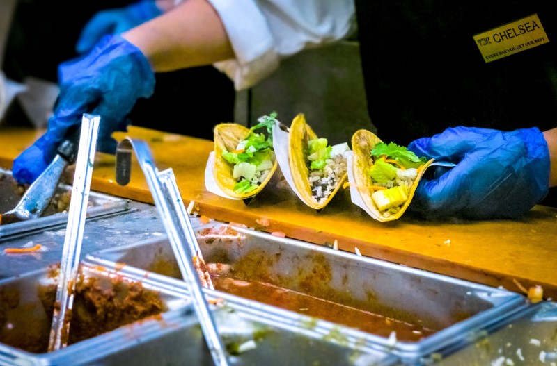 Photo of a worker making tacos